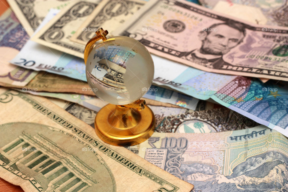 currencies of the various parts of the world with a glass globe