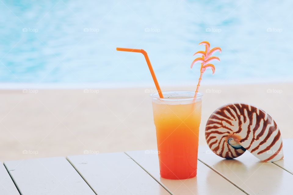 Seashell and orange juice on table