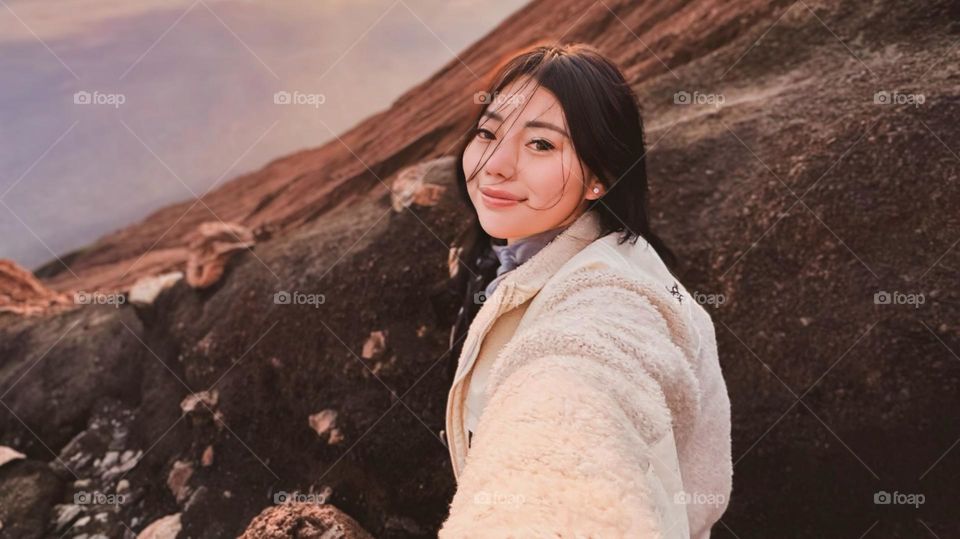 Portrait of a young woman smiling on a hillside in the afternoon