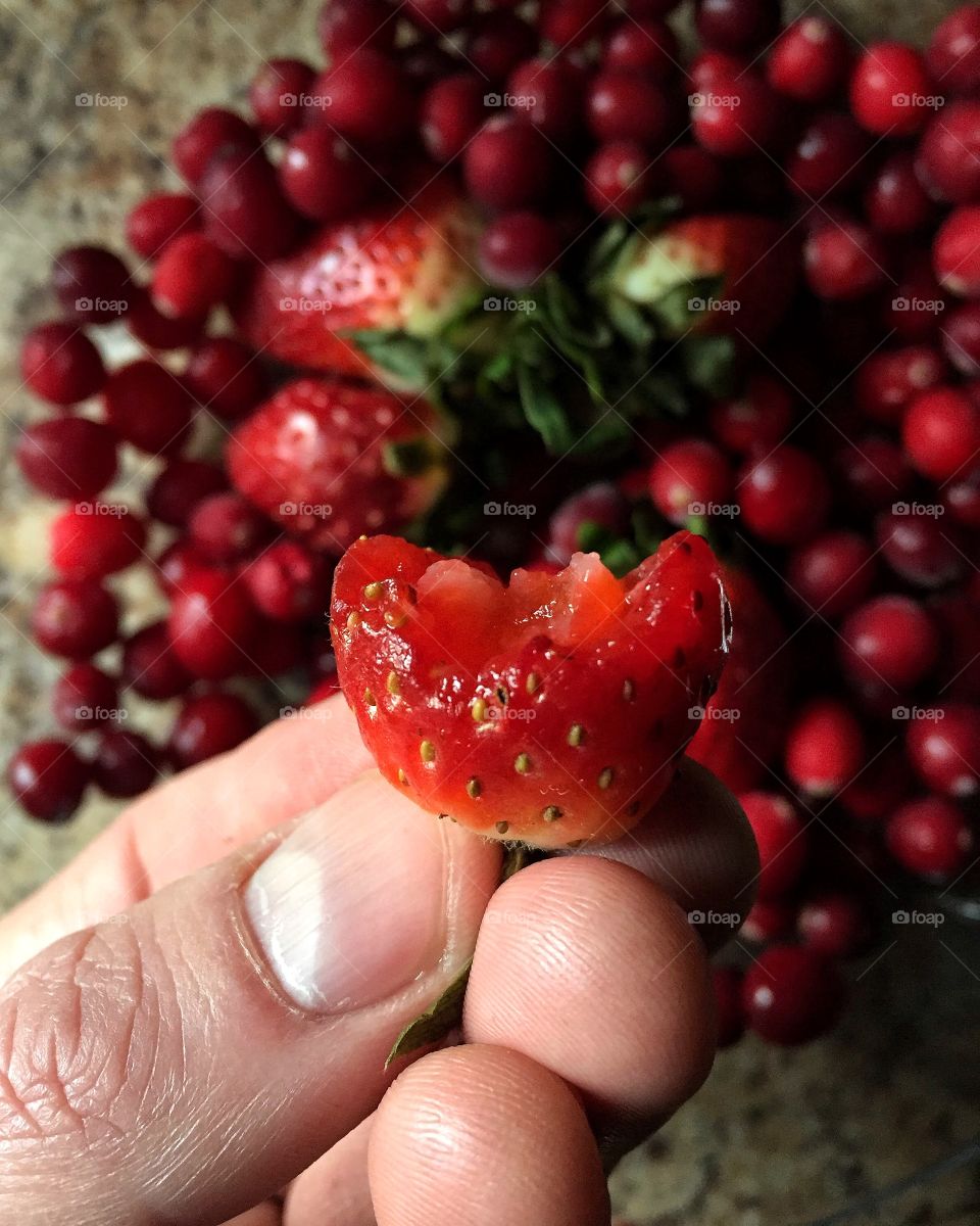 Hand holding strawberry