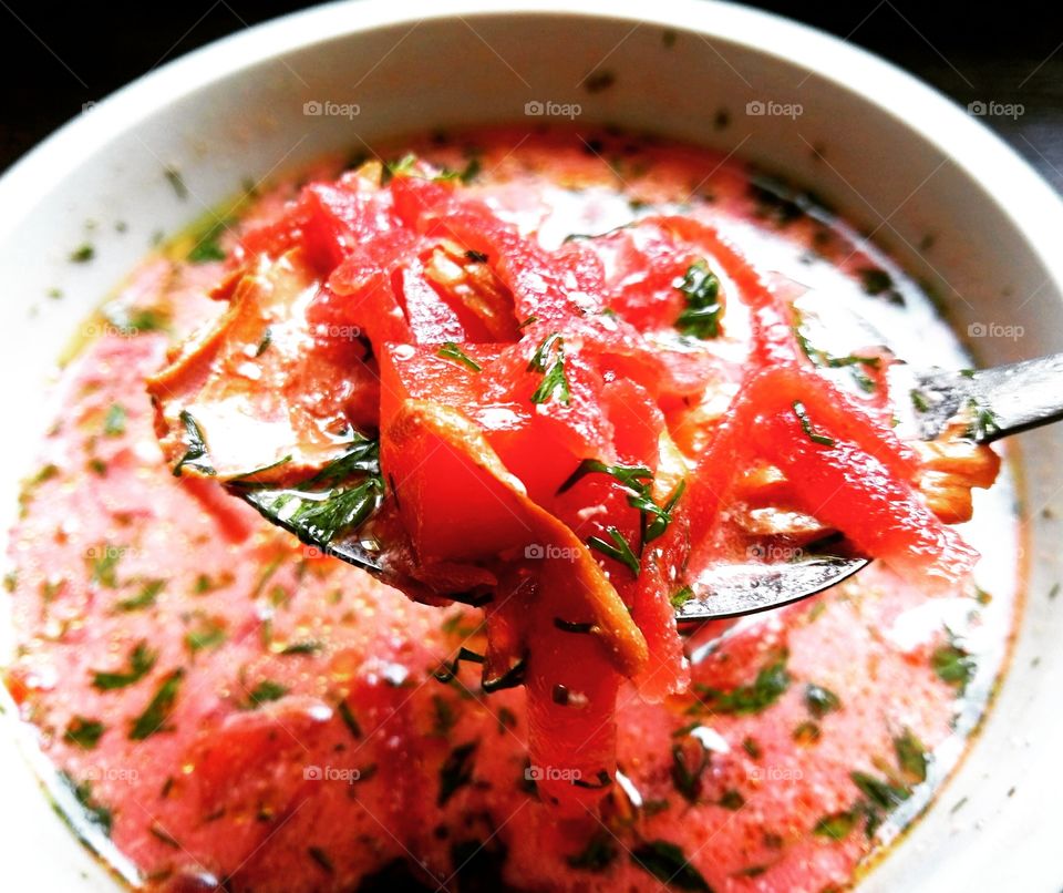 Red beet soup in a white bowl