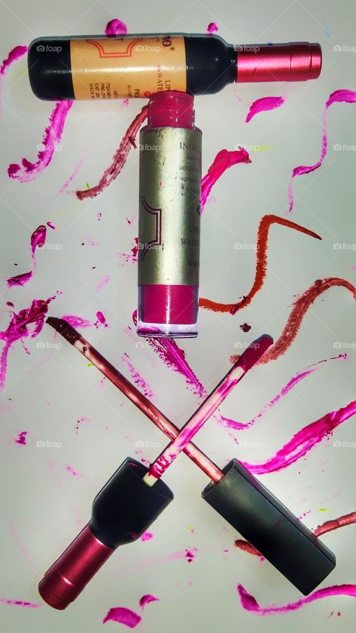 Pink water proof liquid lip tint against a colourful background