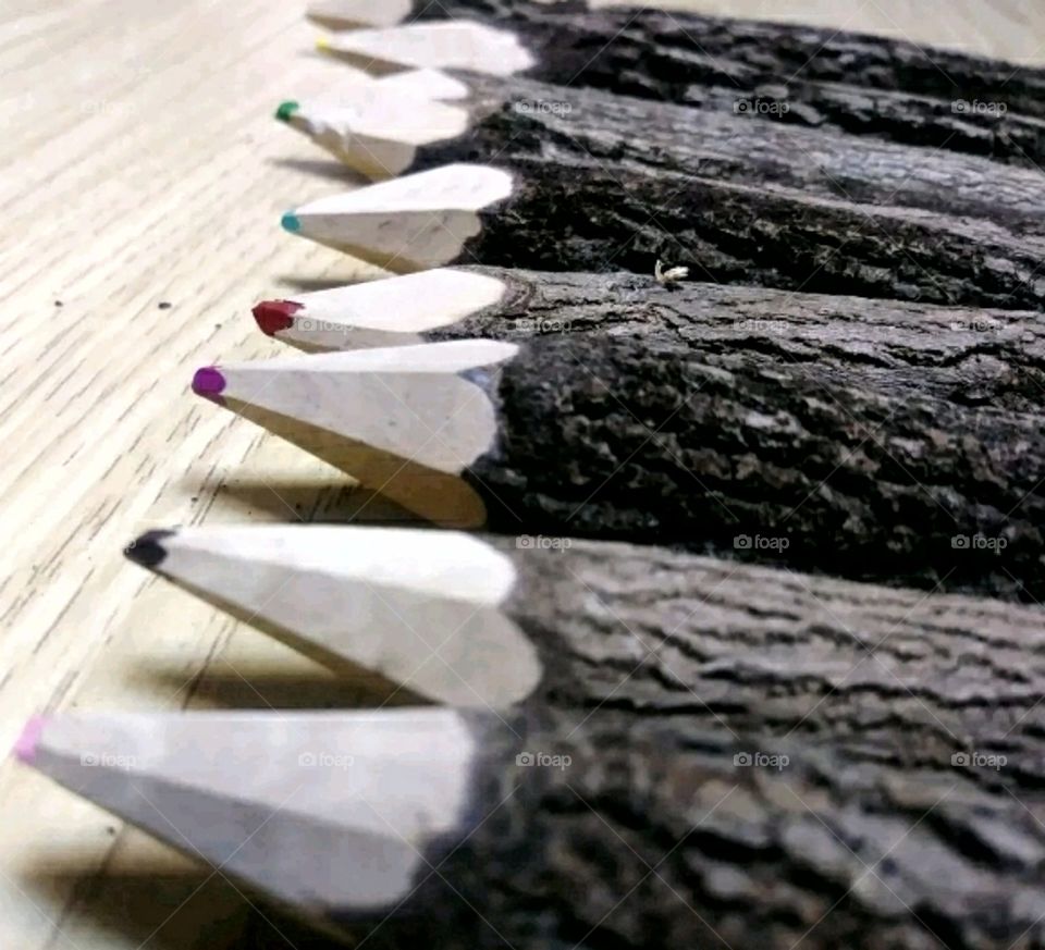 Wooden colored pencils alligned in a row.