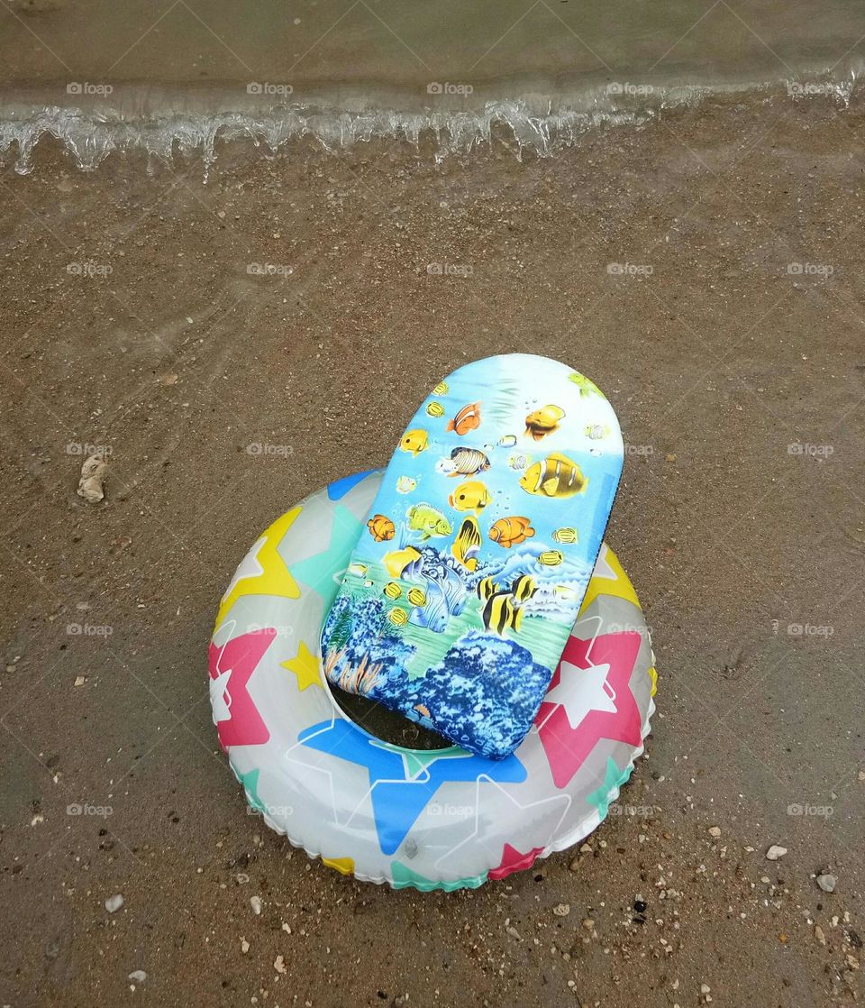 Swimming board and ring on the beach for summer day