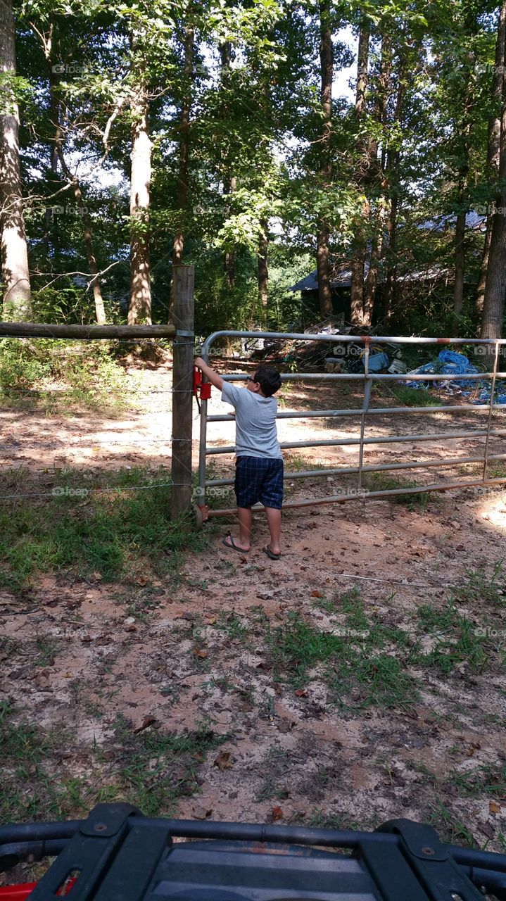 opening a gate. a kid opening a gate