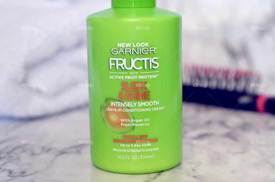 Garnier sleek and shine leave in hair conditioner on a marble background 