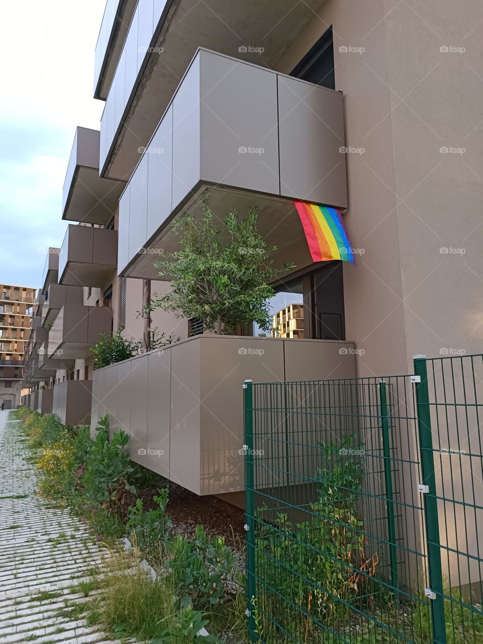 the vibrant colors of the rainbow flag on the balcony, representing the LGBTQ+ community