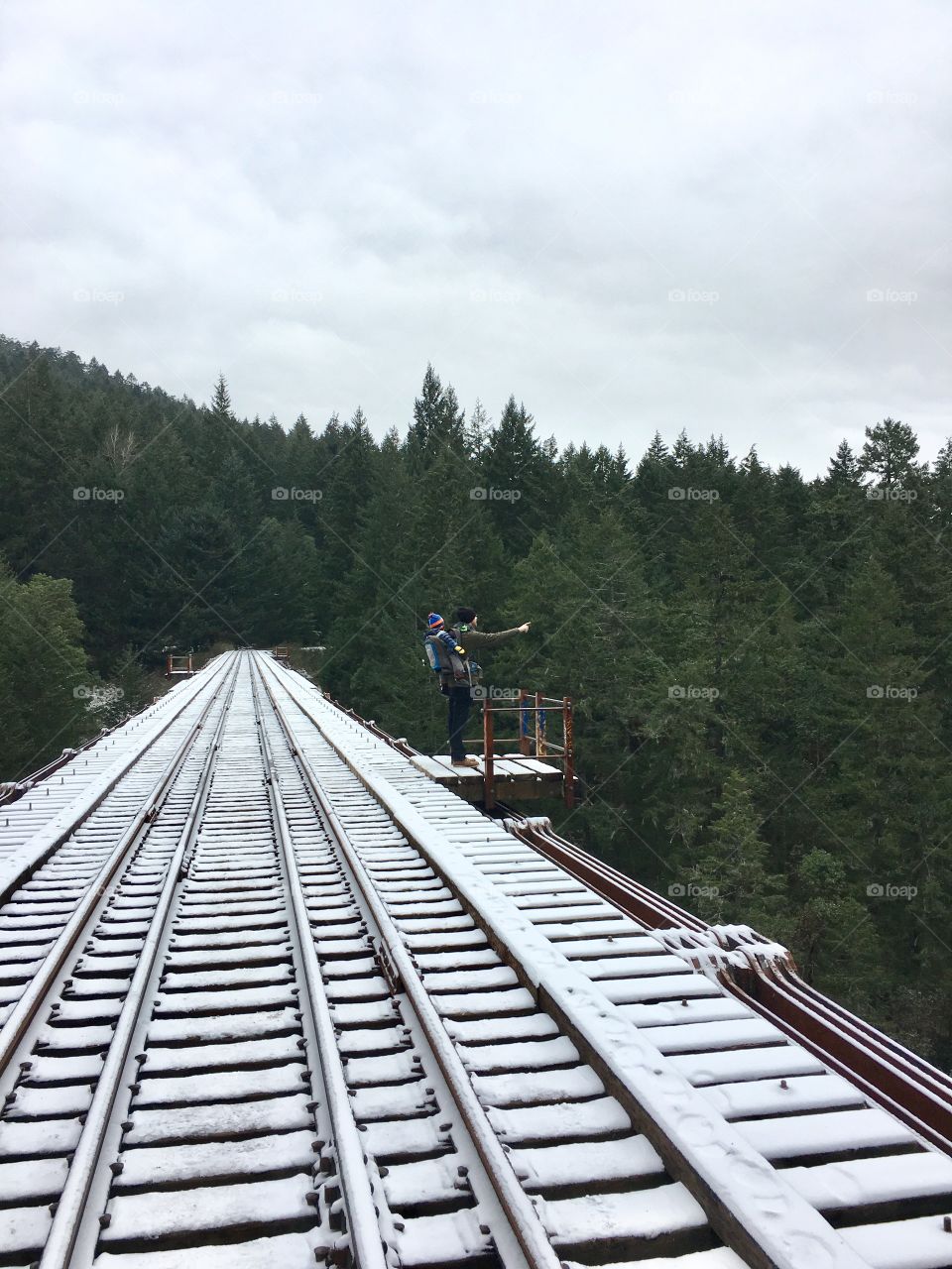 Father and son on at a lookout on a train trestle. 