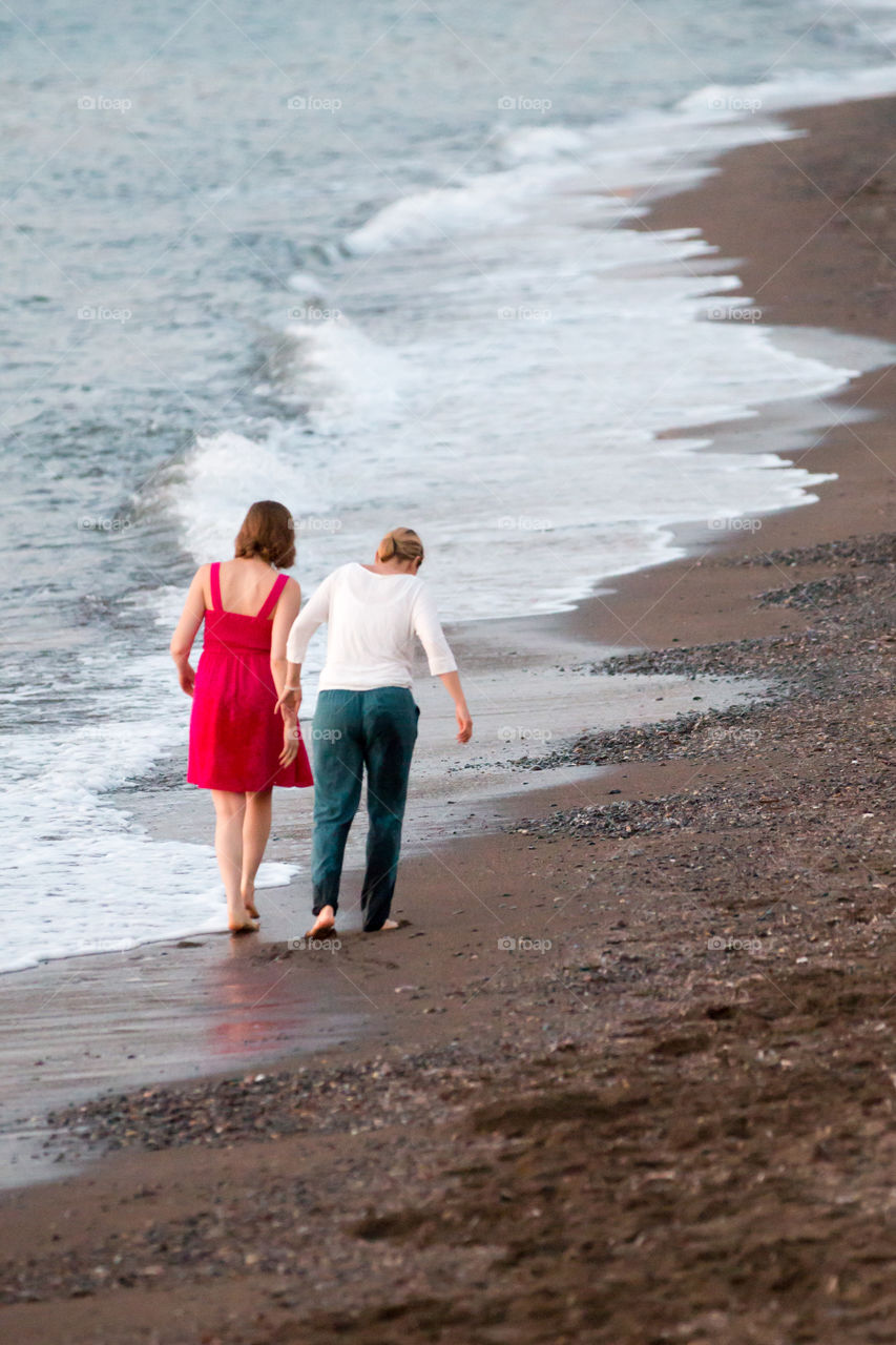 Friends Walking And Talking At The Beach
