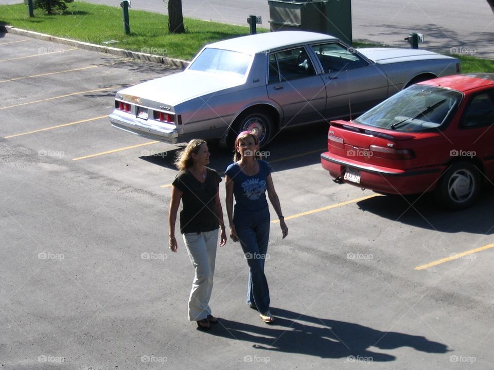 Sisters walking in parking lot. Sisters walking in parking lot