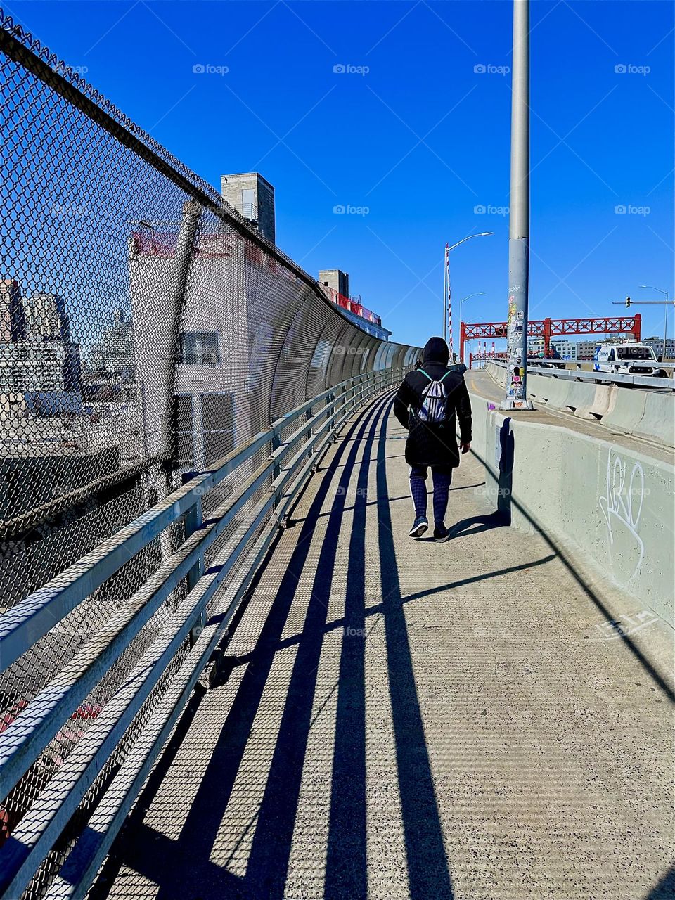 This is the pedestrian lane of the “Pulaski Bridge” at “Newtown Creek” that connects “Greenpoint”, Brooklyn to LIC, Queens, the direction we are now facing. The shadows of the railing make a strong combined statement. 2024. Hypnotic Productions