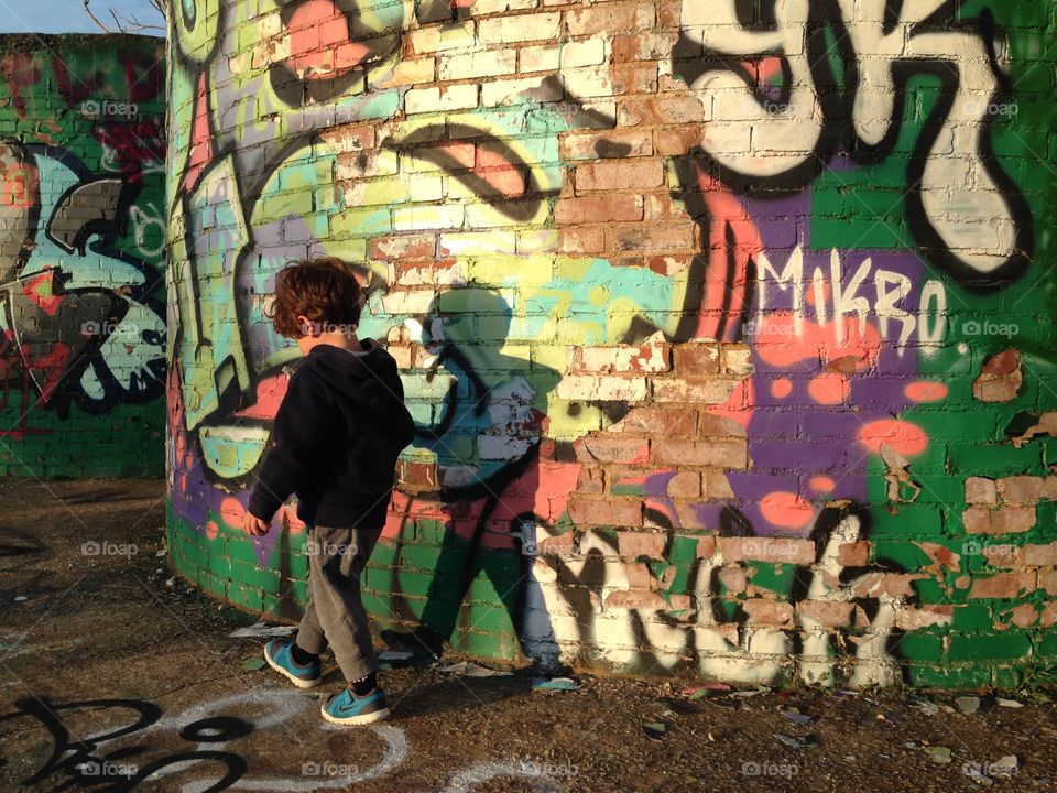 A little boy in front of graffiti in Asheville, NC