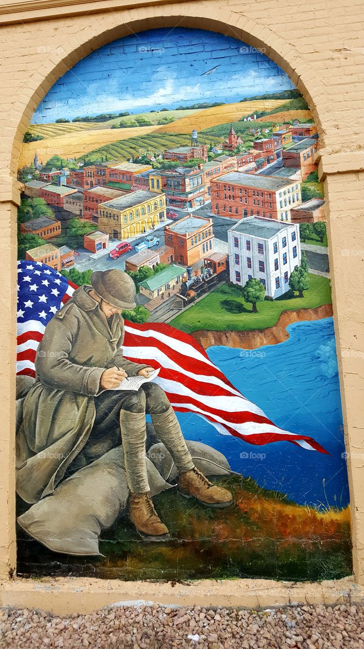 painting of soldier riding in front of American flag and the town of Sauk Centre