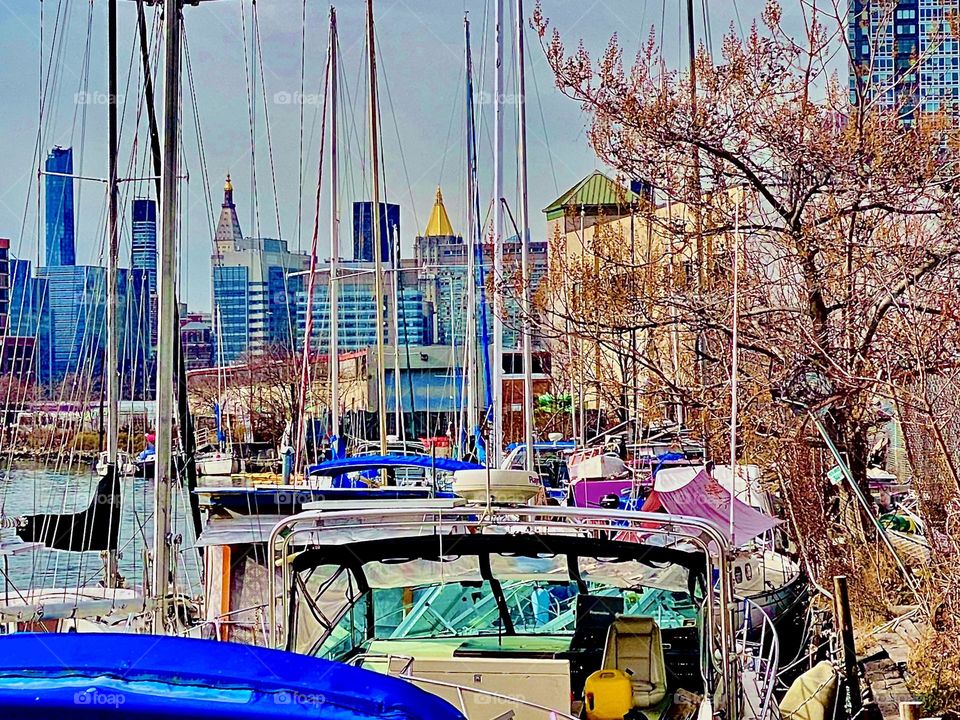 A closeup look at Manhattan from beneath the Pulaski Bridge at Newtown Creek in LIC, Queens shows the “Empire State” and the “New York Life Building” with its golden rooftop built in the 1920s. 2021. Hypnotic Productions