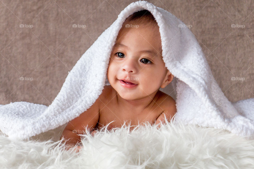 Baby smiling with a towel on his head