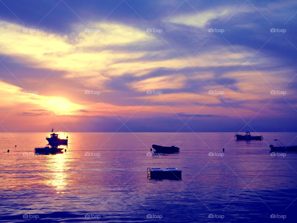 Silhouette of boat reflecting in sea