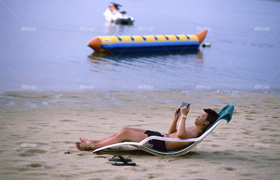 Man using his tablet on the beach