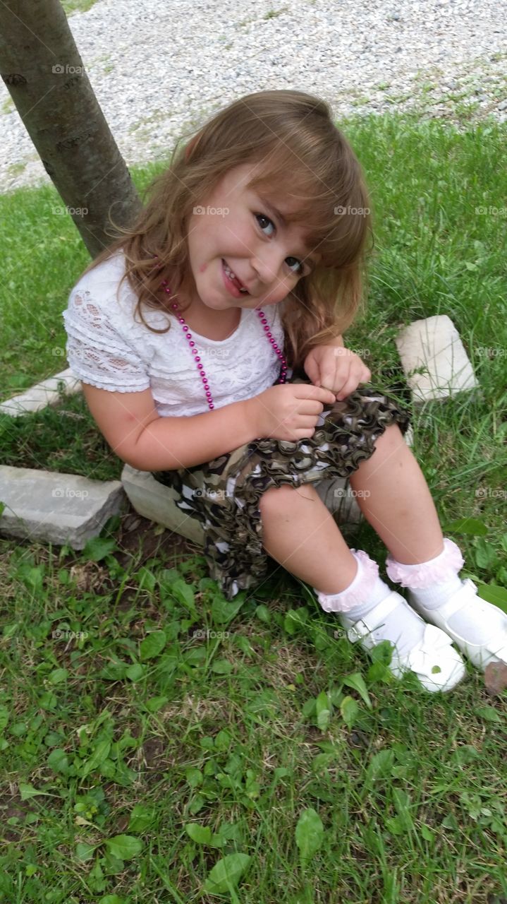 Smiling girl sitting in grass