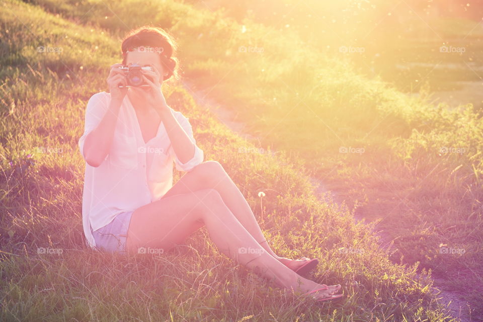 Woman photographing on grassy field