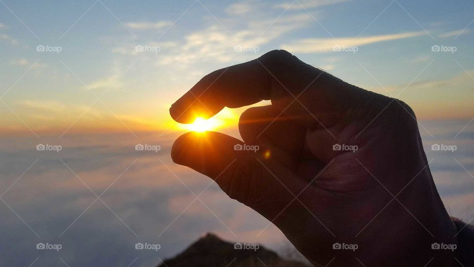 setting sun between thumb and forefinger.
