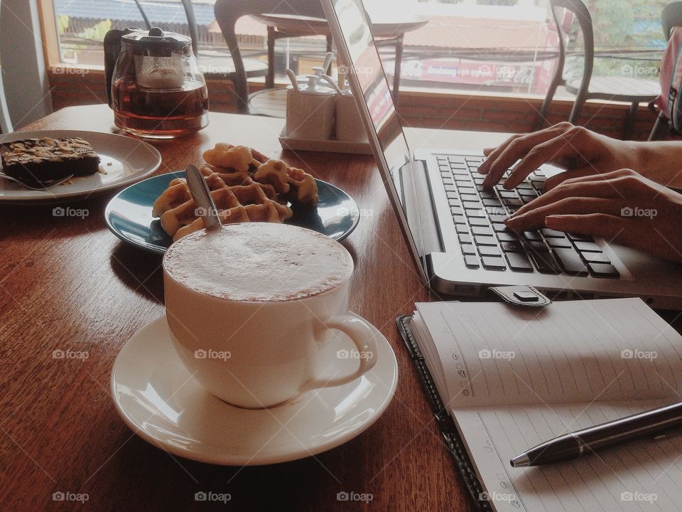 Hands typing on a laptop