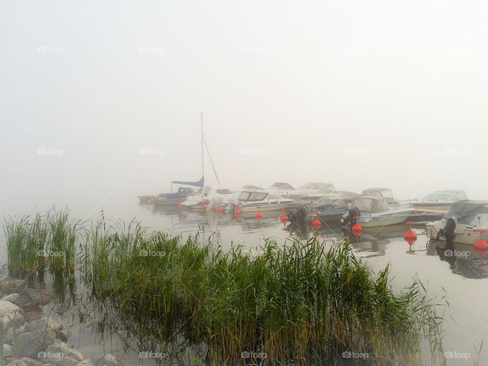 Boats on lake in foggy weather