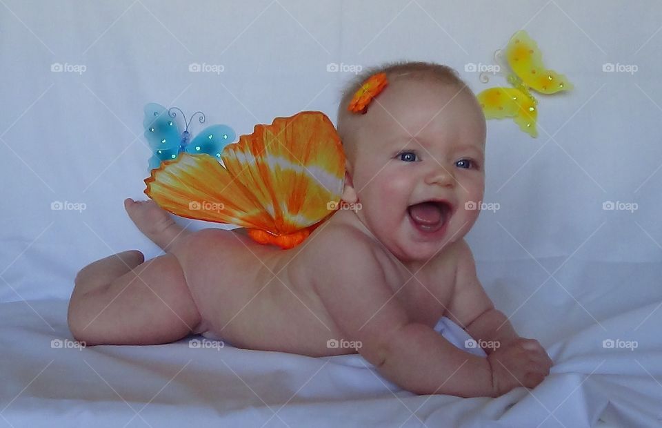 Baby and butterflies. Baby laughing while posing with butterflies.