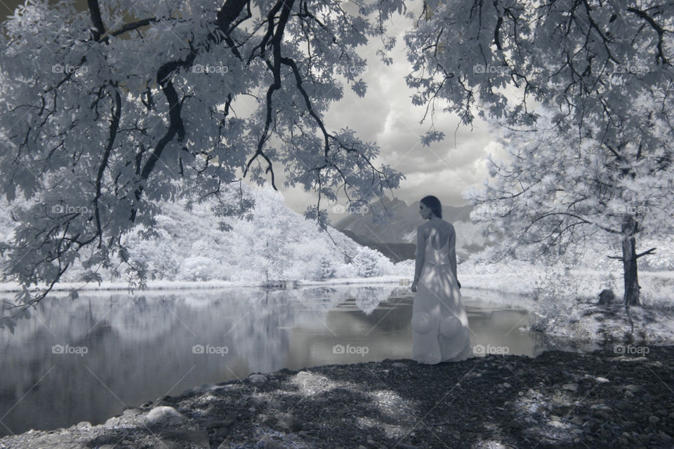 Spring welcoming feeling. Girl by the lake, breathes soft fresh breeze welcoming spring season