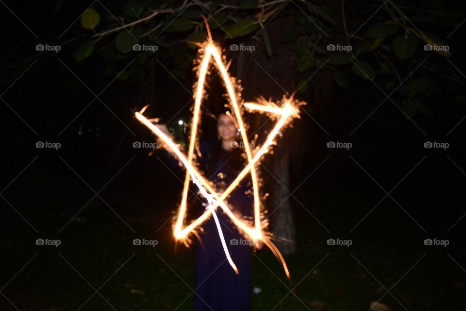 Sparklers painting a star in air adding a much need glow to festival of diwali