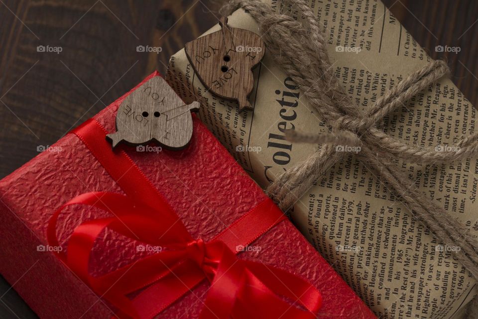 background with red present gift box on wooden table . close up