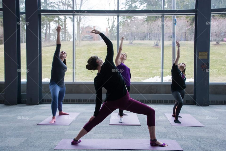 Young woman teaches a yoga session while looking out to a beautiful landscape of mountains 