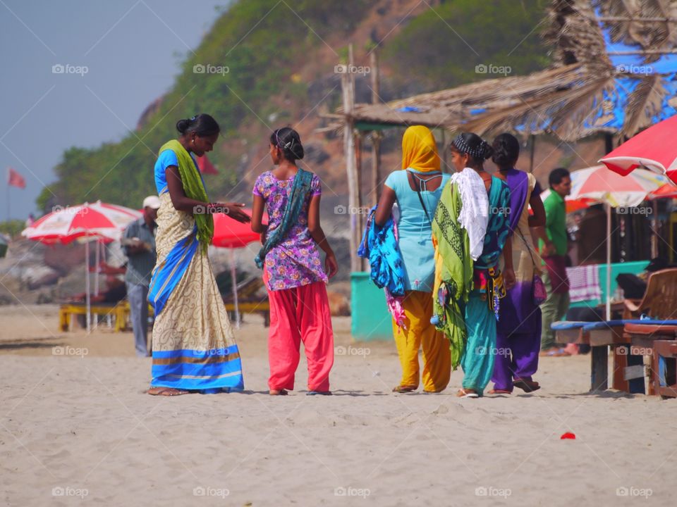 Indian traditionally dressed  women talking to each other in a Goan Beach 