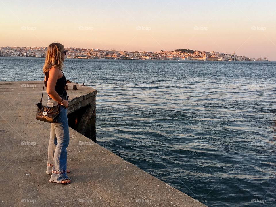 Fashion woman in pier watching sunset 