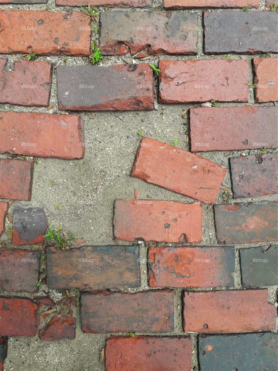 A broken patch in a brick road.