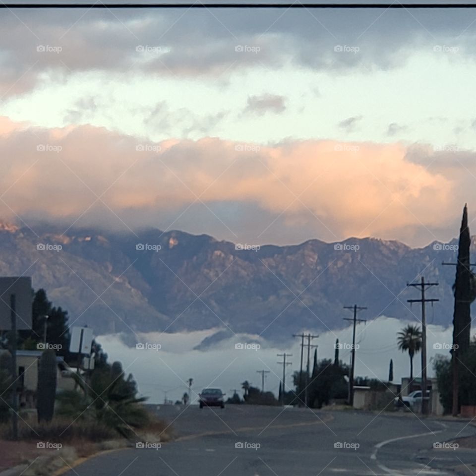 fog below and clouds above the mountains