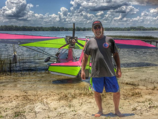 Senior man standing in front of boat