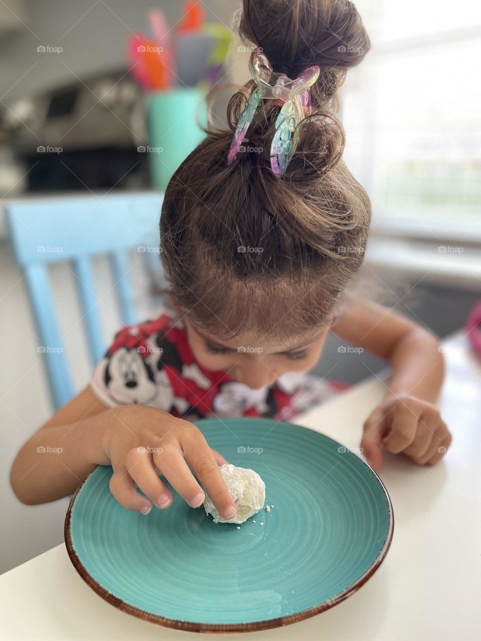 Toddler girl excited about eating cookies, toddler with Mexican wedding cookie, delicious desserts made at home, baking with toddlers 