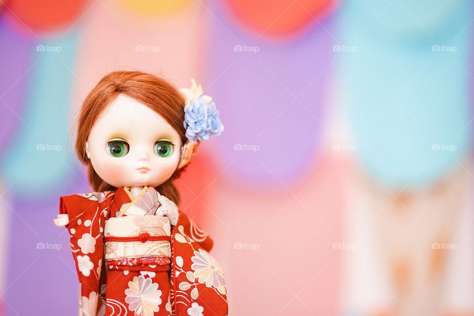 Cute doll wearing kimono. An adorable BJD doll  in red Japanese kimono traditional dress. (BJD is ball-jointed doll)