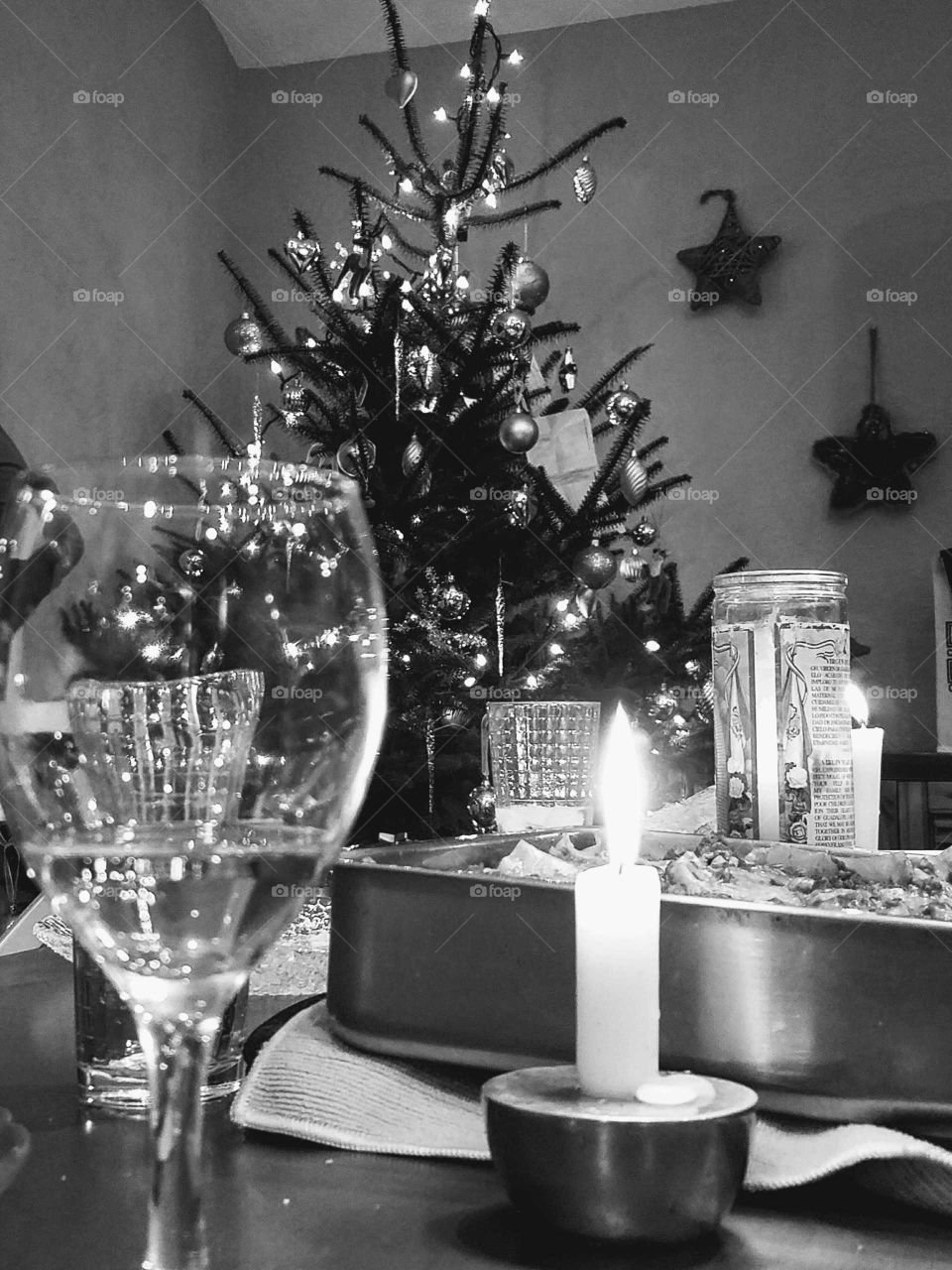 Wine glass in front of decorated christmas tree