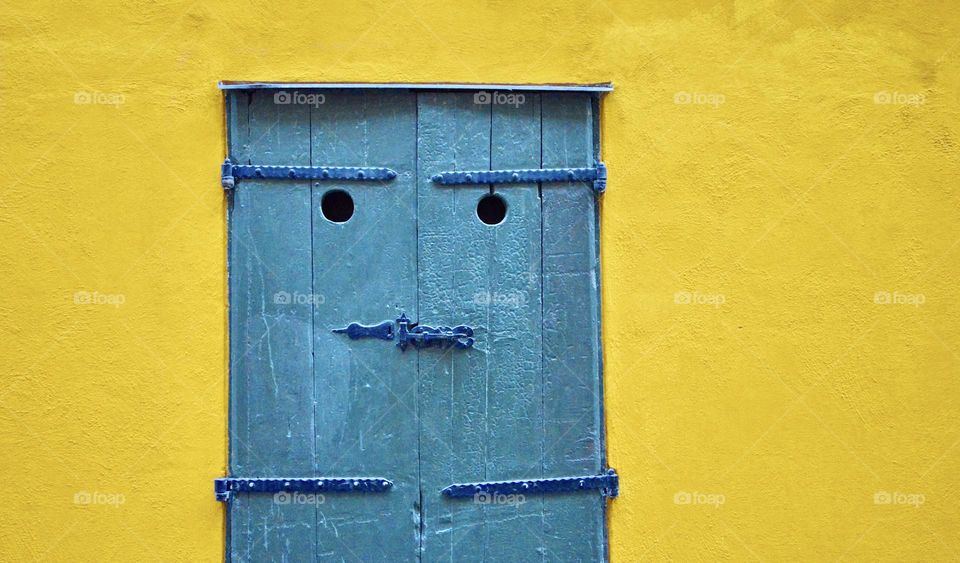 A yellow house with a blue door