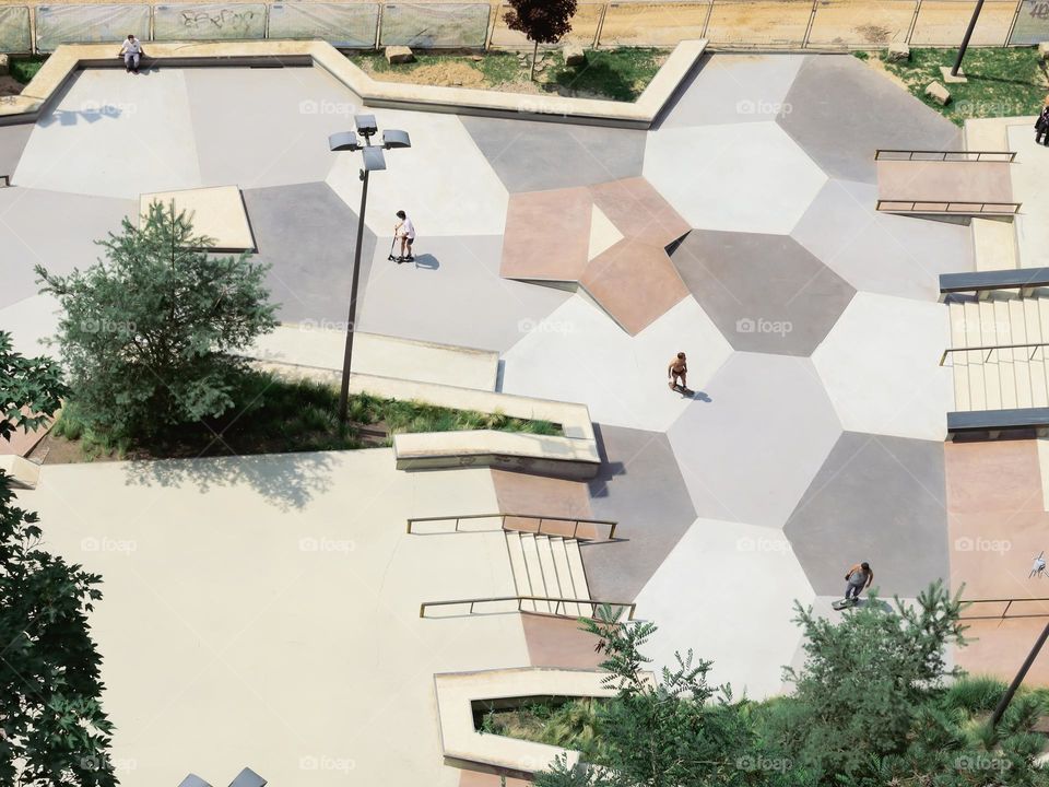 Beautiful view of the skateboarding area with sheometric ornaments, trees, stairs and a skater in Luxembourg city, top view from the bridge in cope plan. Urban lifestyle concept.