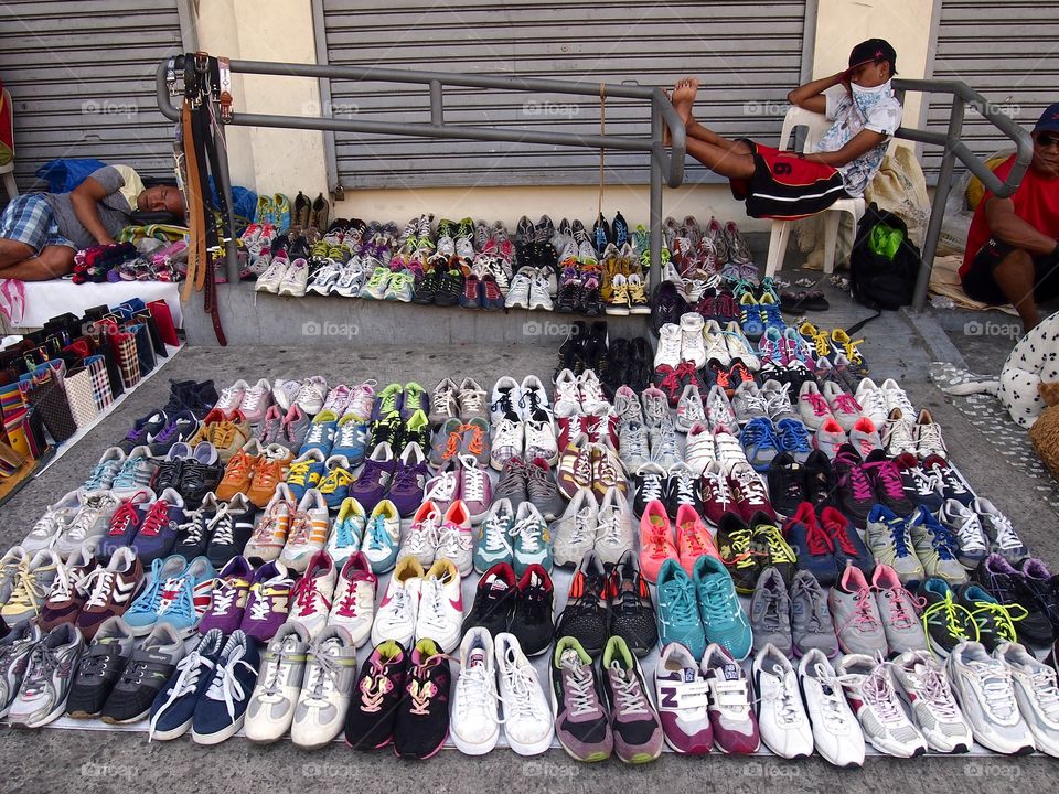 assorted rubber shoes sold at a sidewalk