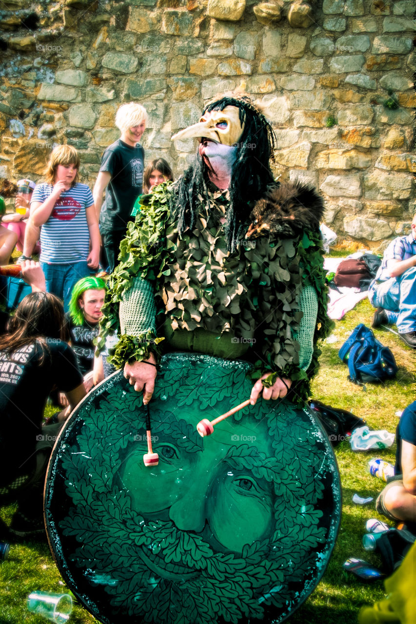 A man dressed in green with a beaked mask, plays a drum at Hastings Traditional Jack in the Green, U.K. 2008
