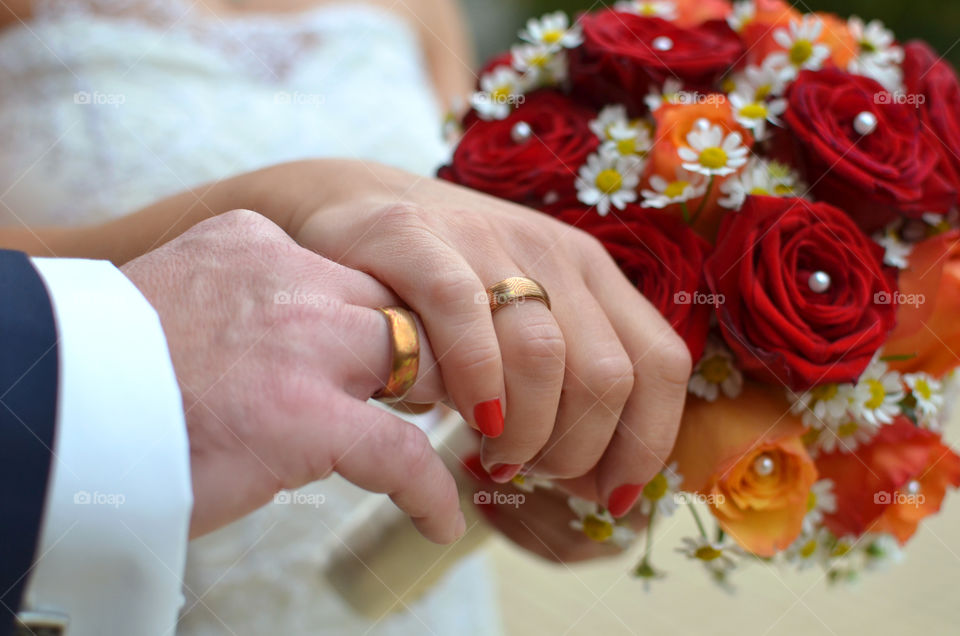 Wedding couple holding hands whilst wearing their new rings