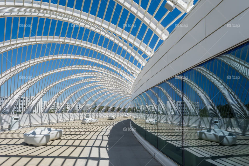 white metal bar design elements on building against a blue sky reflected in the windows causing an abstract image