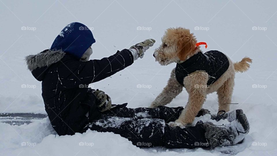 Girls in snow, girl playing with her dog on frozen pond, black coat and vest, dog love