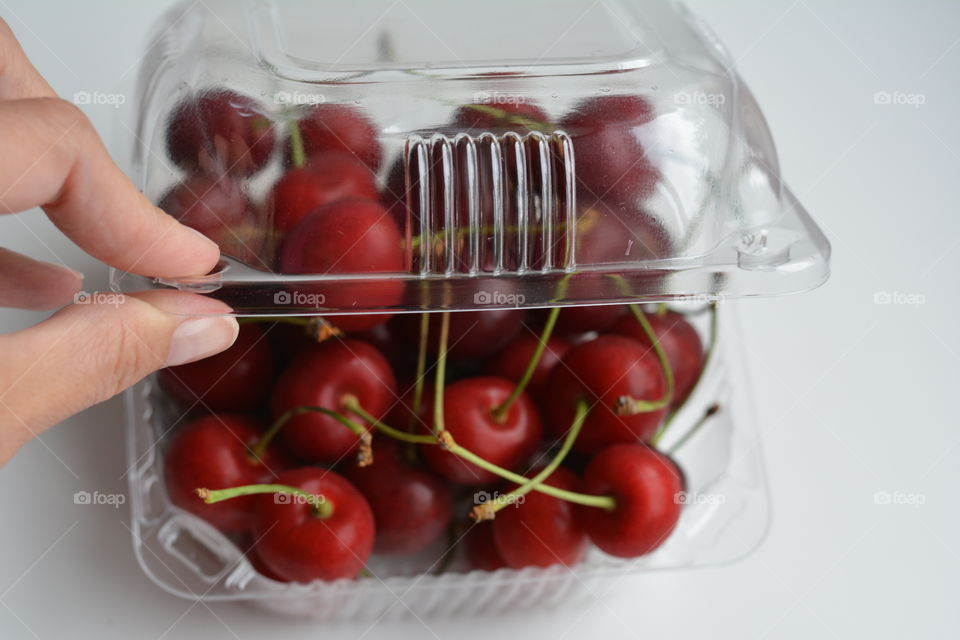 red cherry summer food in the hand white background