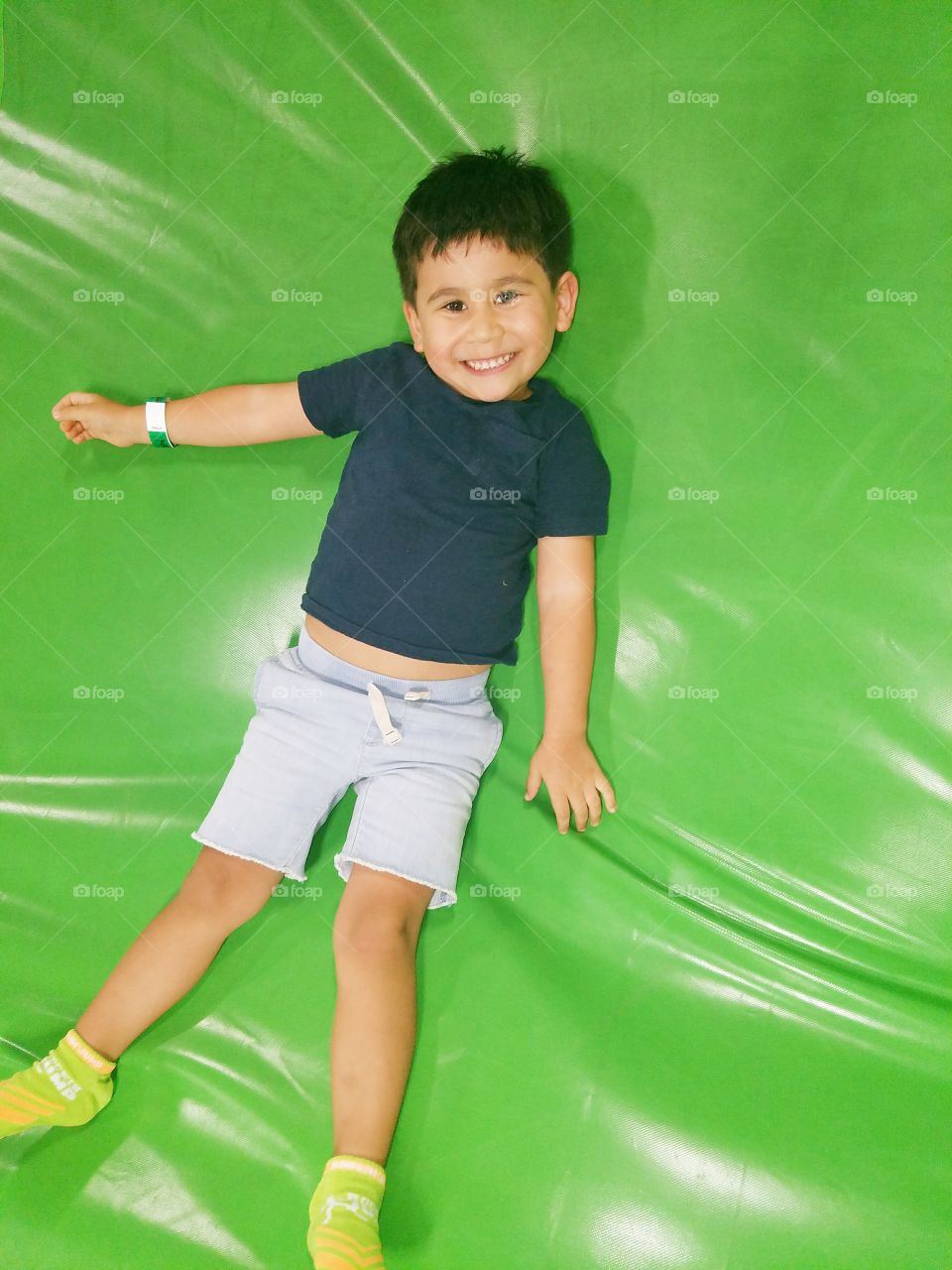 Cute boy lying on bouncy castle