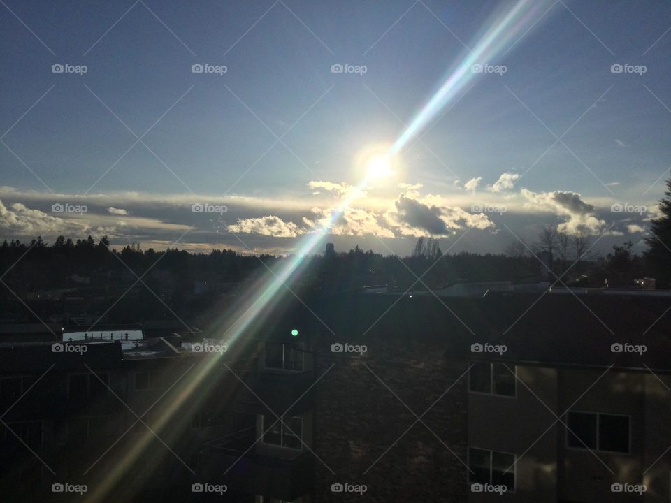 The Sun Peaking through the Clouds over the City 