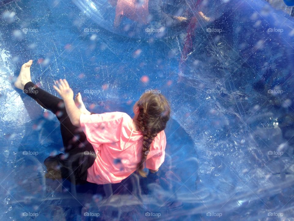 Amusement ride inside bubble on water. Girl in amusement ride